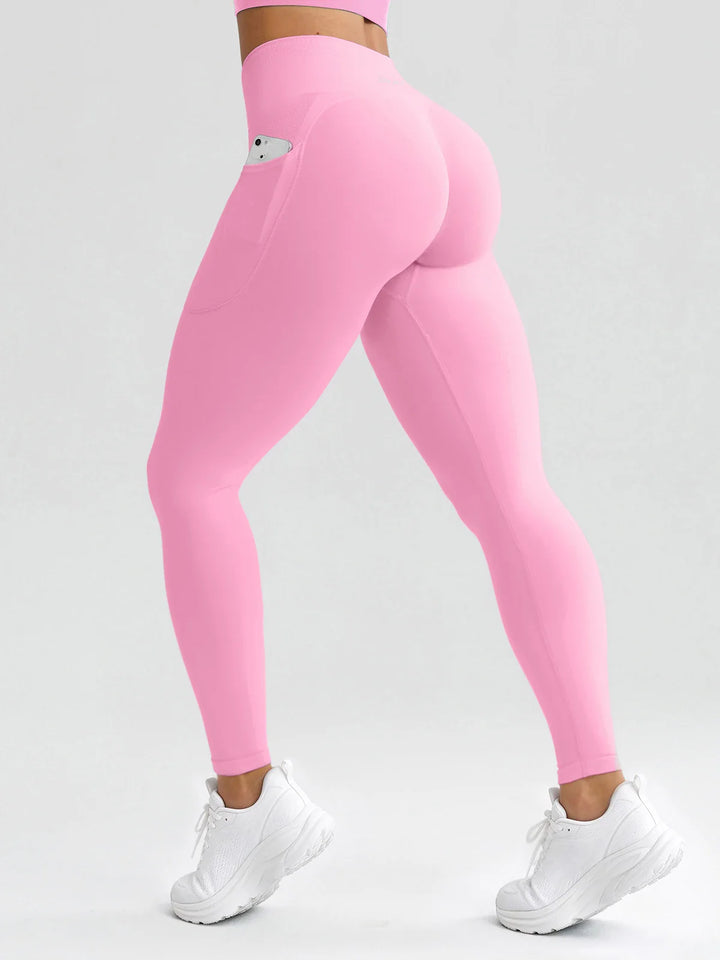 A model wearing a BRXL® B R X L® Seamless High Waisted Butt-Lifting Leggings with Pockets Baby Pink / S