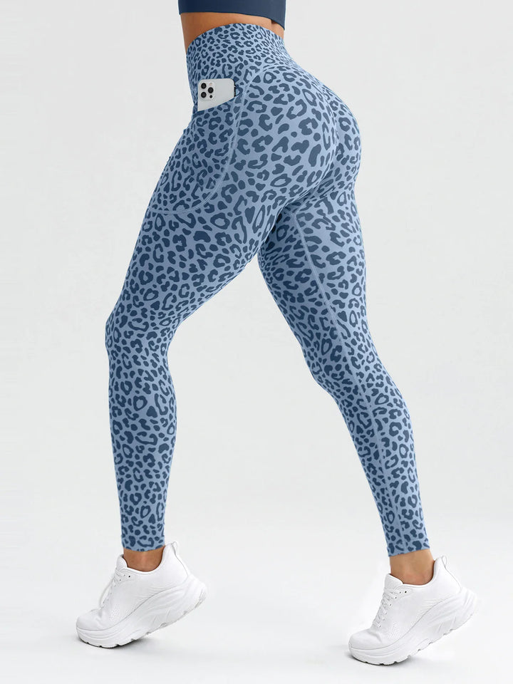 A model wearing a BRXL® B R X L® Seamless High Waisted Butt-Lifting Leggings with Pockets Blue Leopard / S