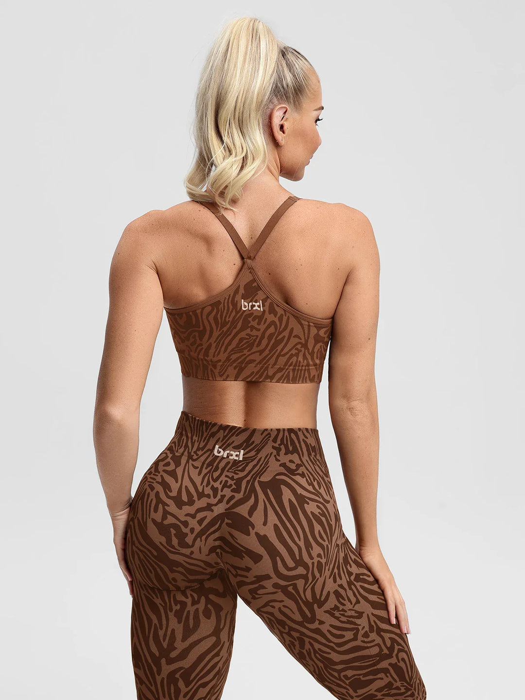 A model wearing a BRXL® B R X L®  V Neck Sculpt Seamless Ruched Y Back Sports Bra