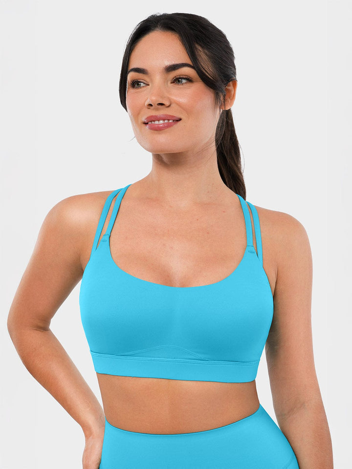 A model wearing a BRXL® BrxlZero™ Cross Back Strappy Sports Bra in Light Blue / XS