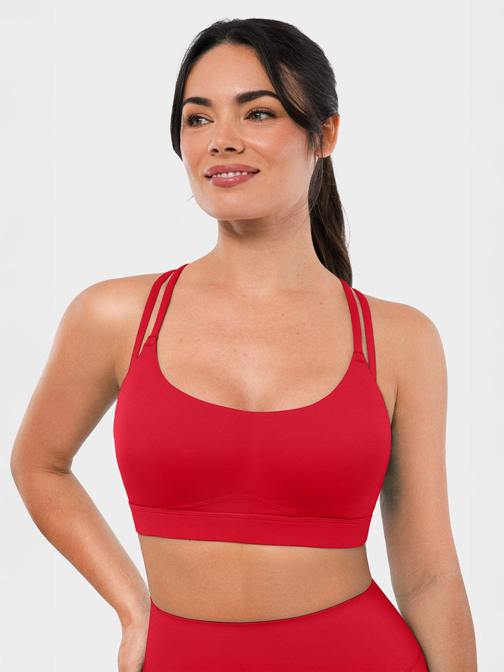 A model wearing a BRXL® BrxlZero™ Cross Back Strappy Sports Bra in Red / XS