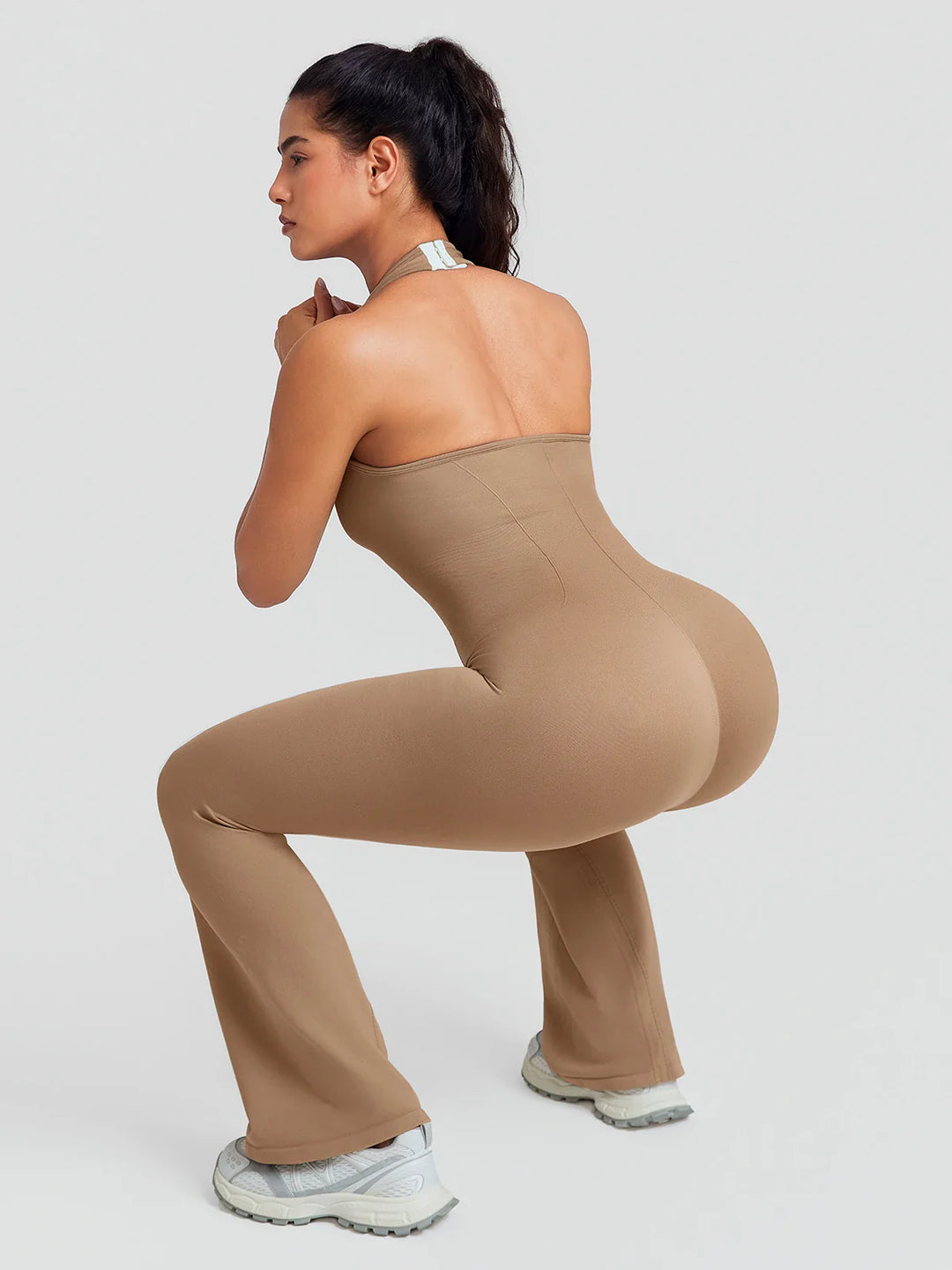 A model wearing a BRXL® BrxlZero® Halter Neck Sculpt Seamless Flare Jumpsuit