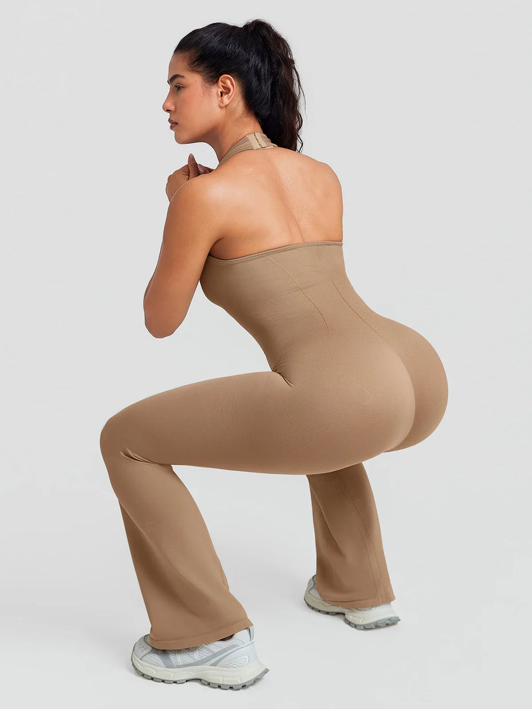 A model wearing a BRXL® BrxlZero® Halter Neck Sculpt Seamless Flare Jumpsuit