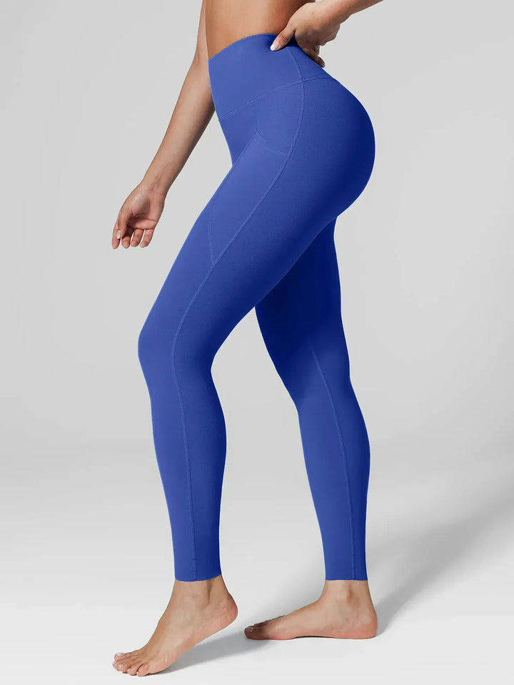 A model wearing a BRXL® BrxlZero™ High Rise Side Pockets Buttery Soft Yoga Leggings in Blue / XS