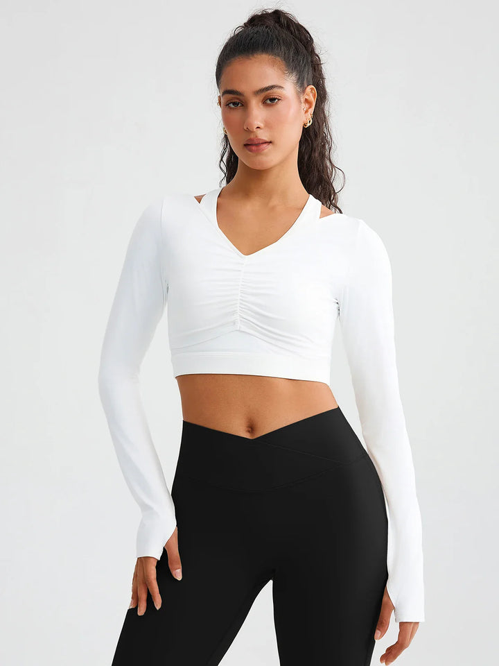 A model wearing a BRXL® BrxlZero® Off Shoulder Long Sleeve Crop Top with Built-In Bra White / XS