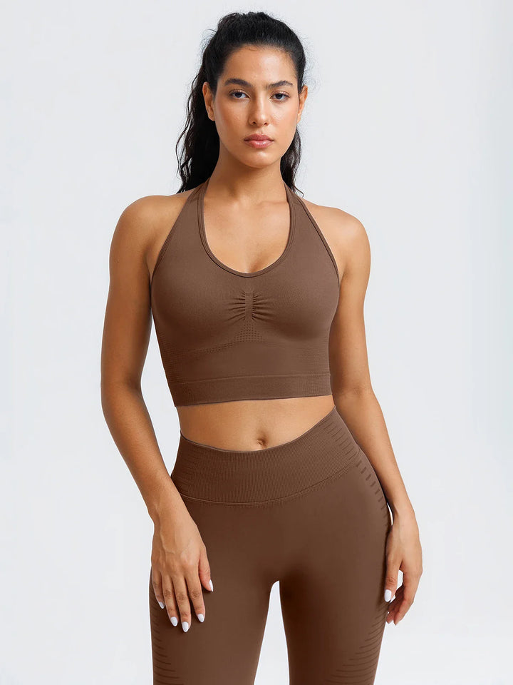 A model wearing a BRXL® BrxlZero® Seamless Ribbed Scoop-Neck Halter Sports Tank Top Chocolate Brown / XS