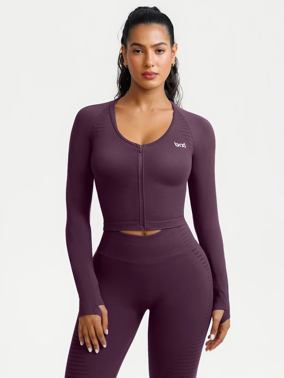 A model wearing a BRXL® BrxlZero® Seamless Scoop-Neck Long Sleeve Cropped Jacket Dark Plum / XS