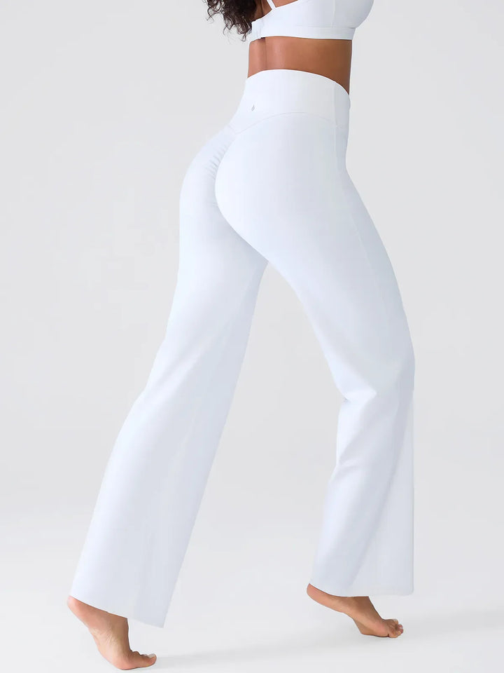 A model wearing a BRXL® Butt Lift Wide Leg Workout Pants in White / XS