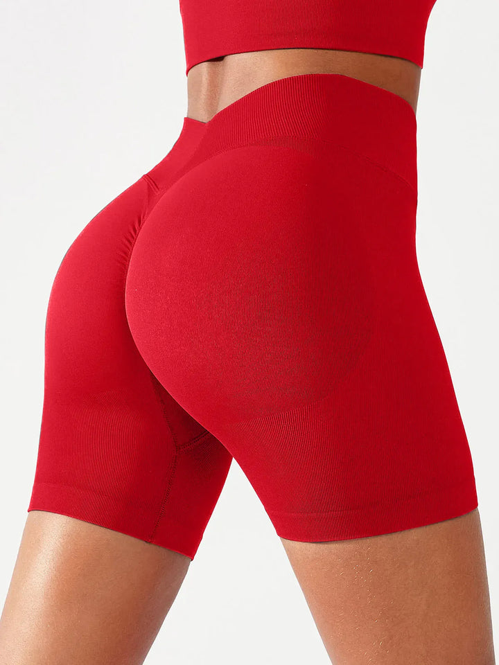 A model wearing a BRXL® Butt Lifting Seamless Bra Scrunch Leggings Set in Shorts / Red / XS