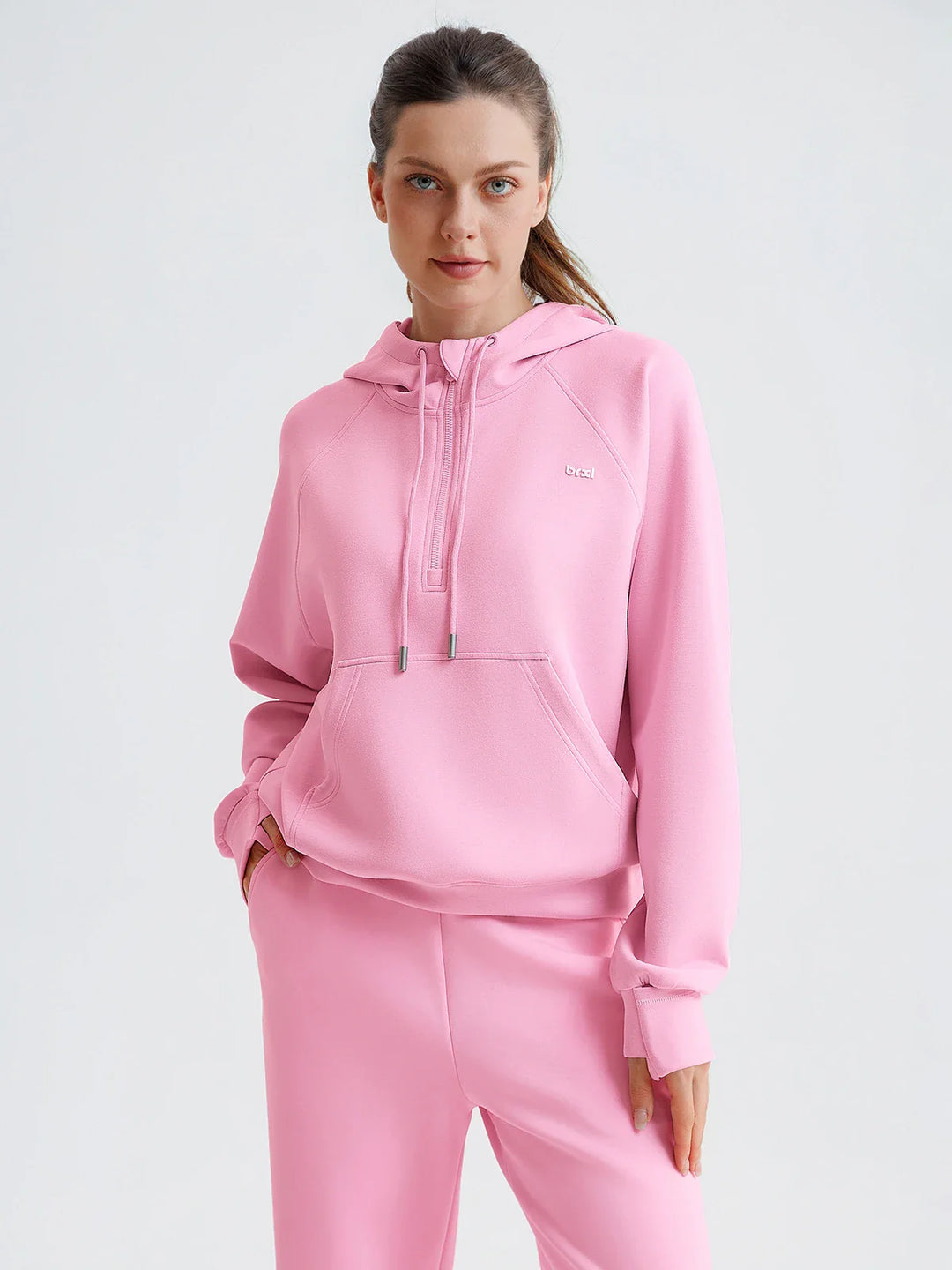 A model wearing a BRXL® Cropped Half-Zip Pullover Comfort Hoodie Baby Pink / XS
