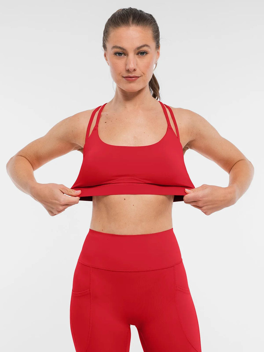 A model wearing a BRXL® Cross Strap Sports Bra High-Waisted Shorts Set in