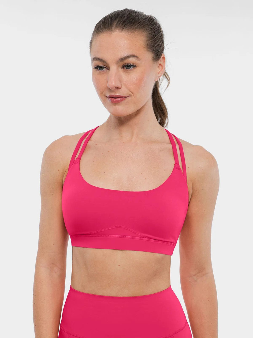 A model wearing a BRXL® Cross Strap Sports Bra High-Waisted Shorts Set in
