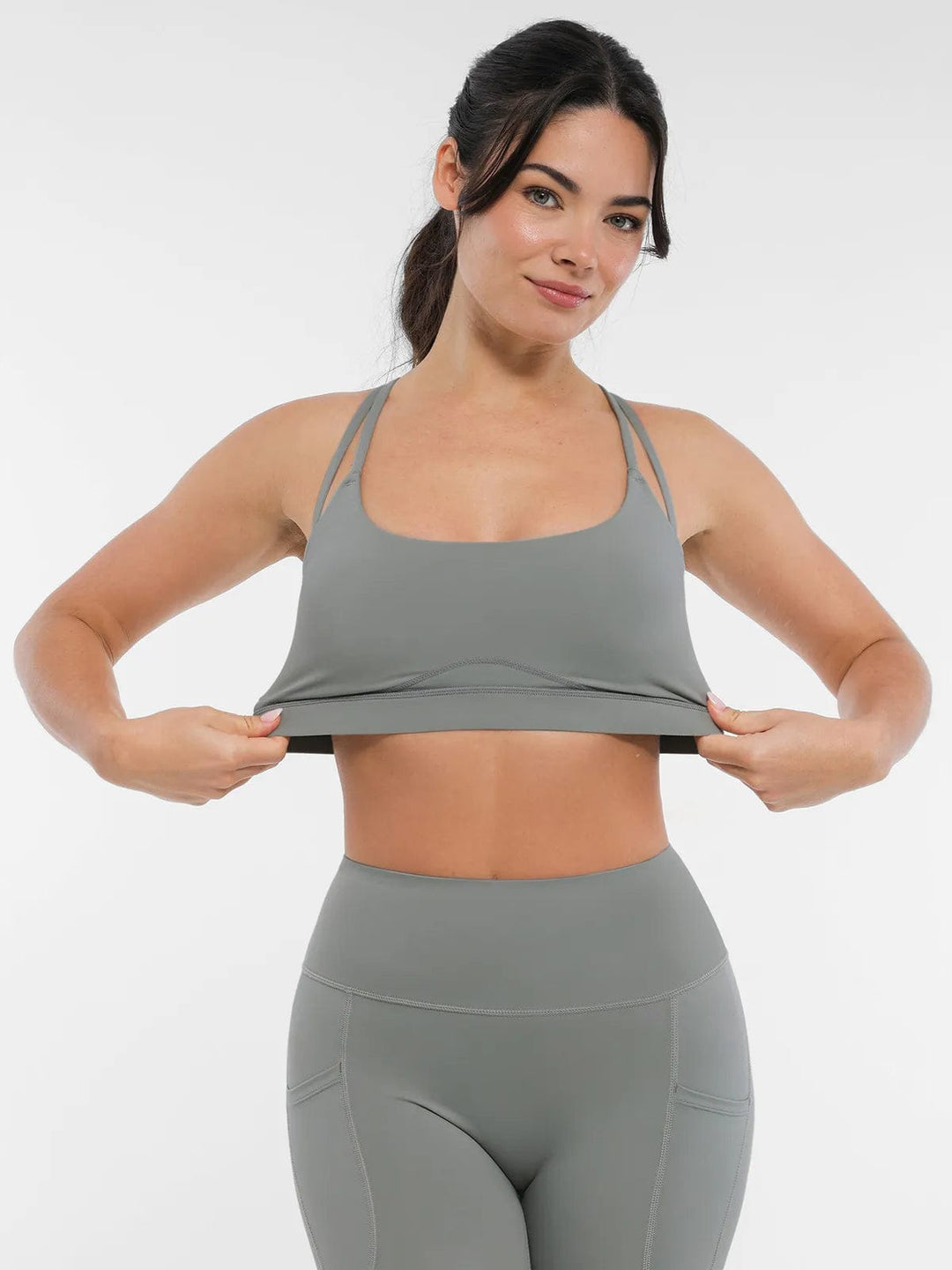 A model wearing a BRXL® Cross Strap Sports Bra High-Waisted Shorts Set in