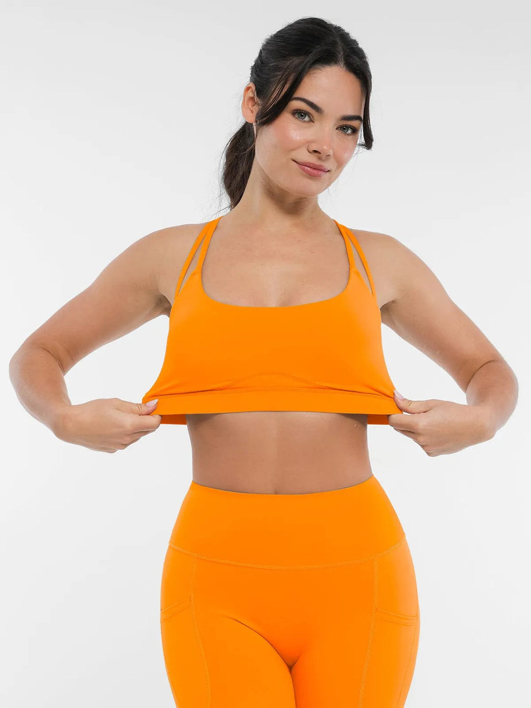A model wearing a BRXL® Cross Strap Sports Bra High-Waisted Shorts Set in