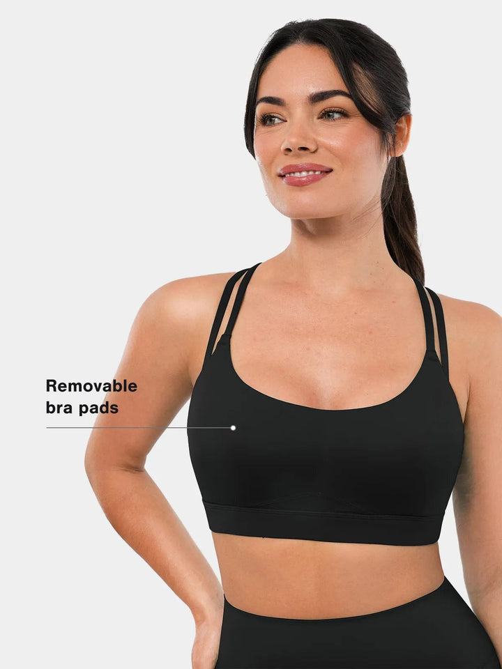 A model wearing a BRXL® Cross Strap Sports Bra Sculpted Leggings Set in