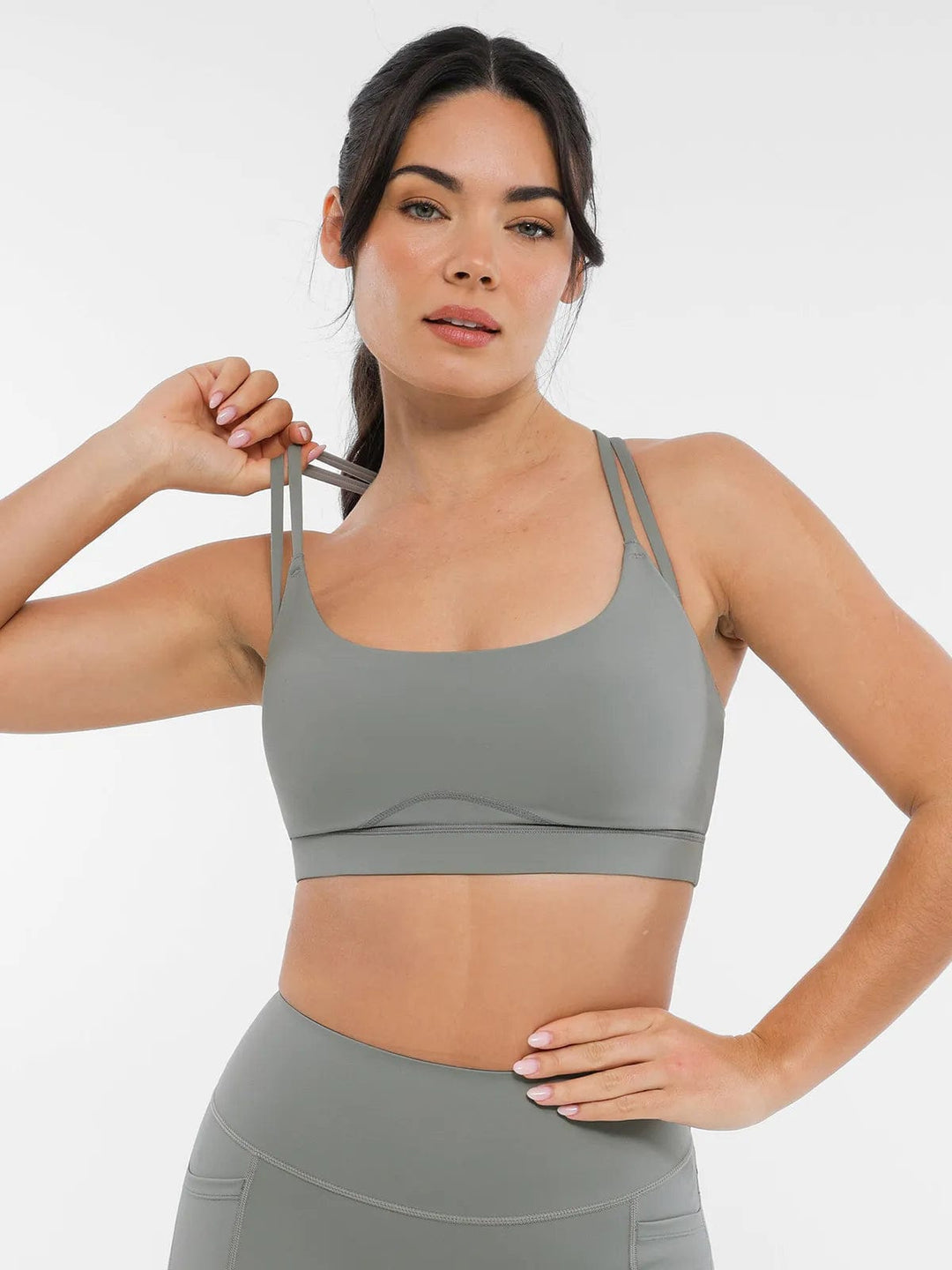 A model wearing a BRXL® Cross Strap Sports Bra Sculpted Leggings Set in