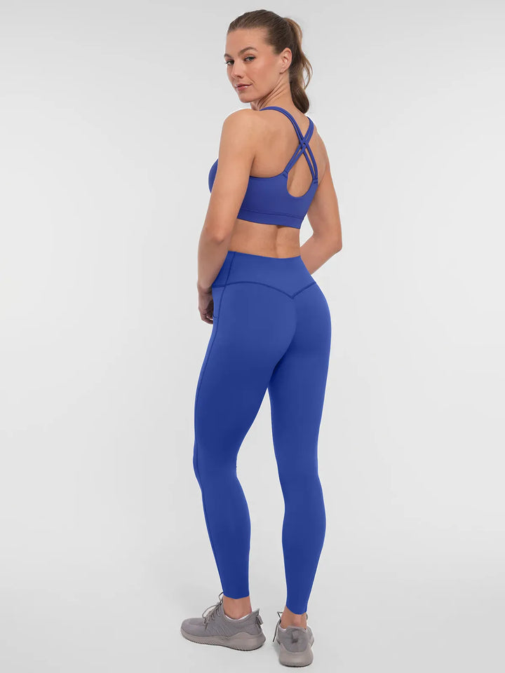 A model wearing a BRXL® Cross Strap Sports Bra Sculpted Leggings Set in