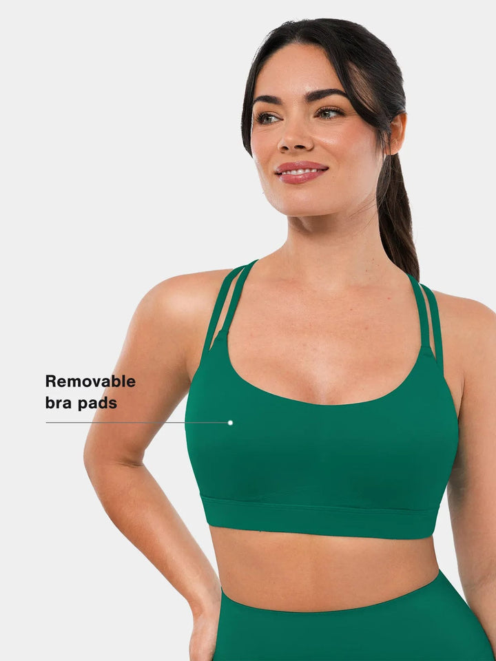A model wearing a BRXL® Cross Strap Sports Bra Sculpted Leggings Set in Bra / Green / XS