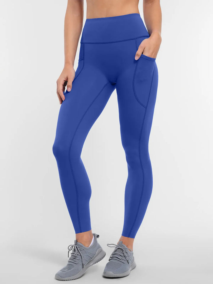 A model wearing a BRXL® Cross Strap Sports Bra Sculpted Leggings Set in Leggings / Blue / XS