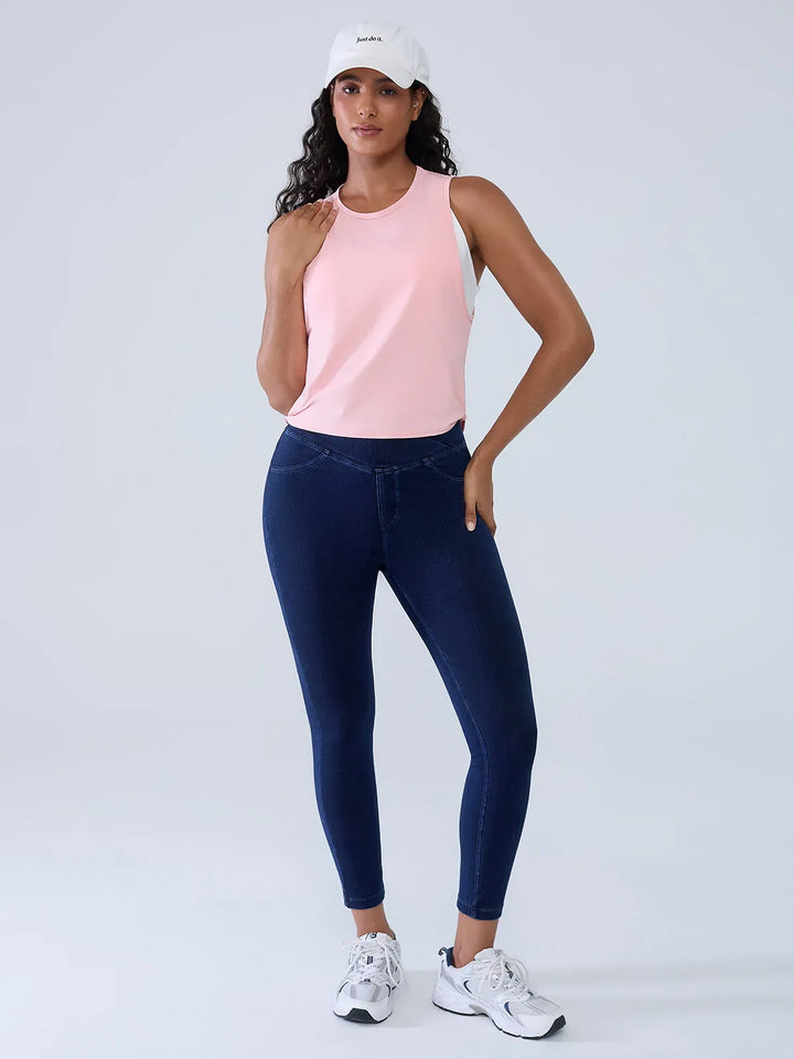 A model wearing a BRXL® Crossover Denim Sculpting Leggings with Pockets in