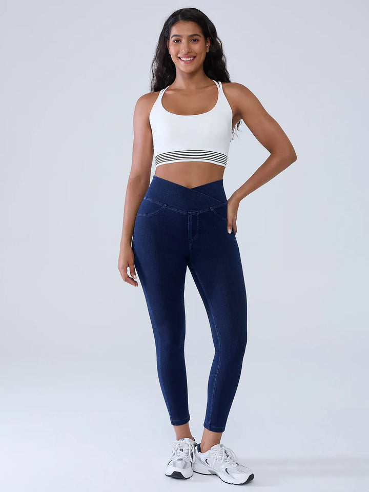A model wearing a BRXL® Crossover Denim Sculpting Leggings with Pockets in