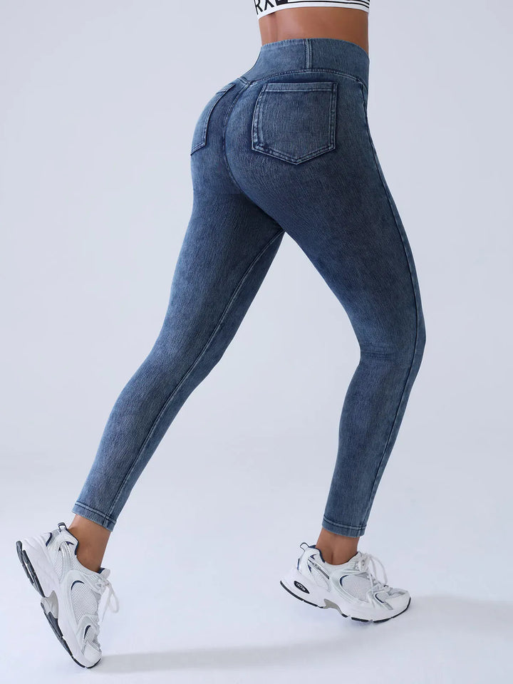 A model wearing a BRXL® Crossover Denim Sculpting Leggings with Pockets in