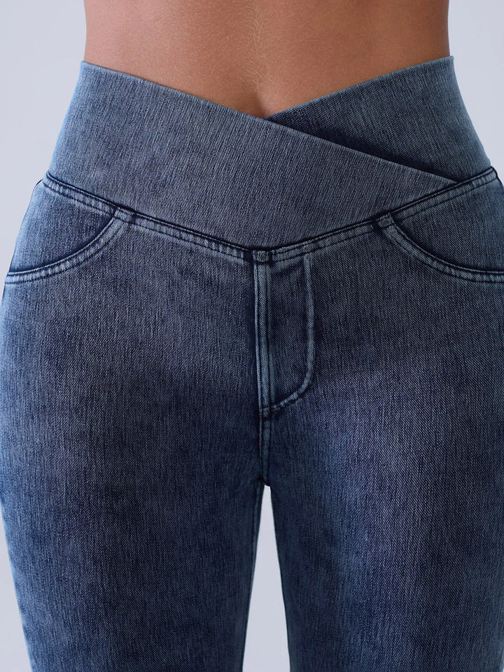 A model wearing a BRXL® Crossover Denim Sculpting Leggings with Pockets in