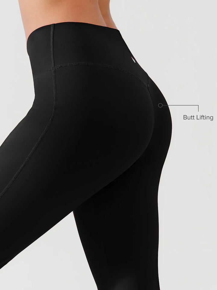 A model wearing a BRXL® Crossover Flared Yoga Pants in
