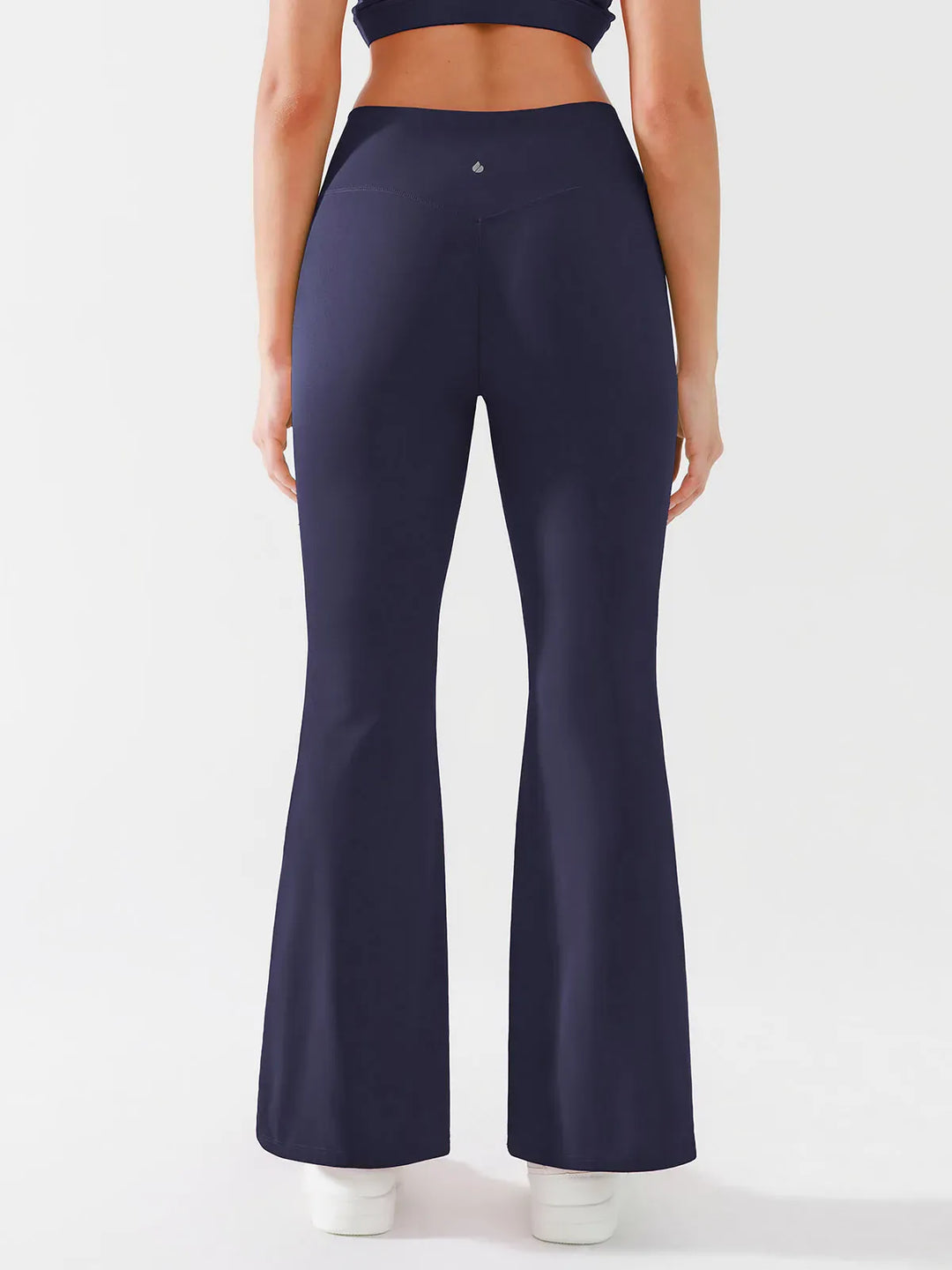 A model wearing a BRXL® Crossover Flared Yoga Pants in