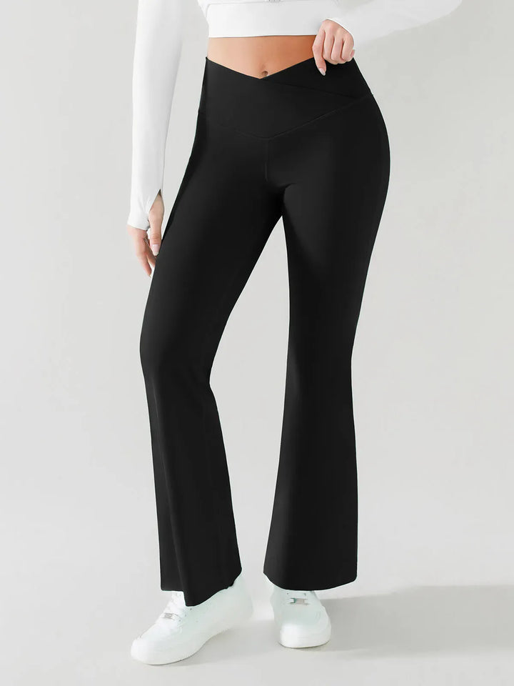 A model wearing a BRXL® Crossover Flared Yoga Pants in Black / XS