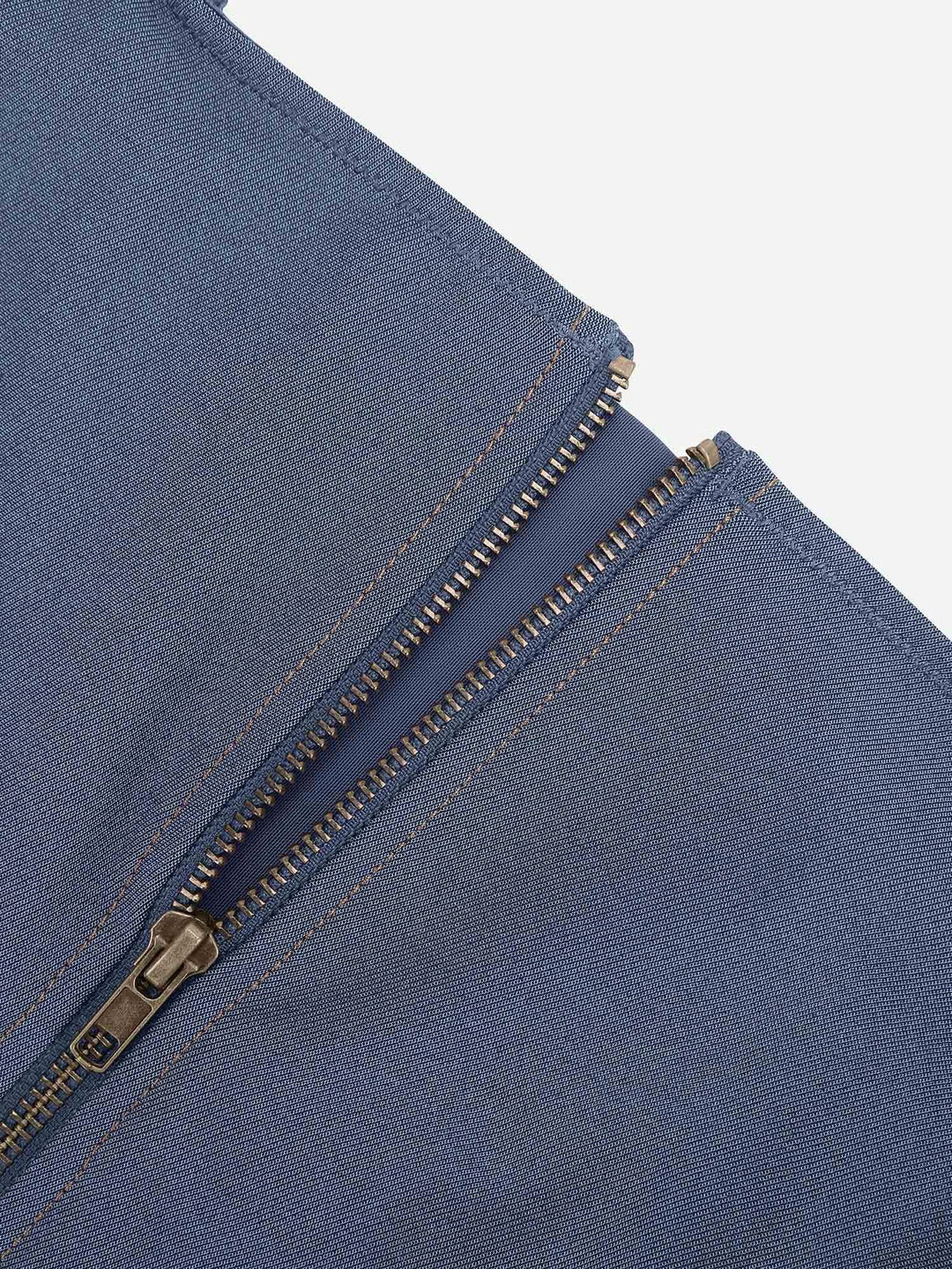 Blue denim shapewear romper detail with antique bronze zip front and contrast stitching.