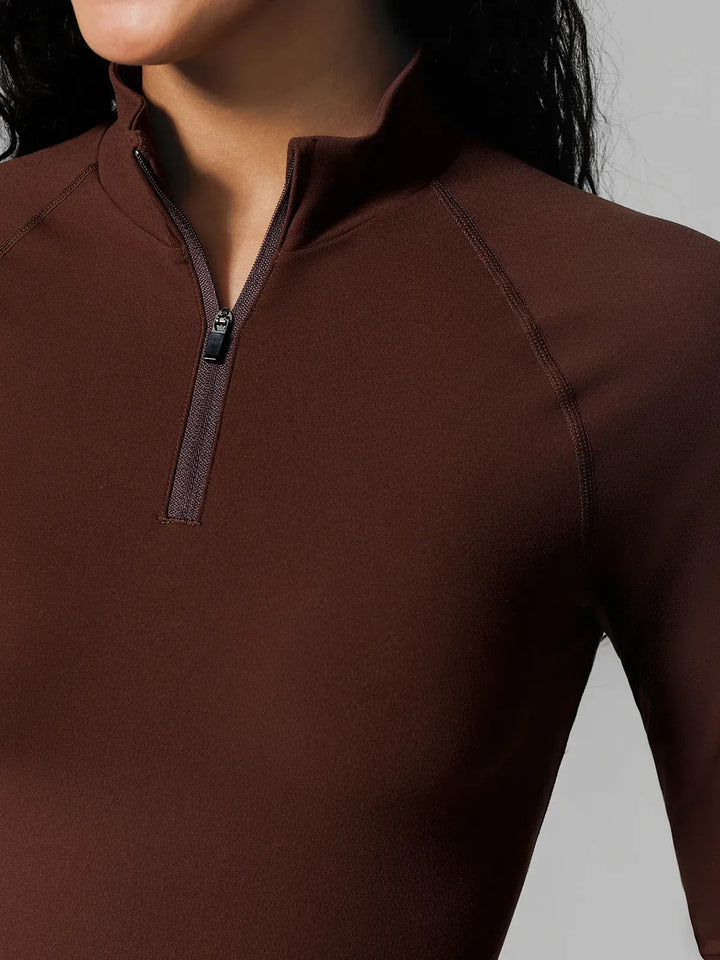 A model wearing a BRXL® Half Front Zipper Activewear Cropped Top in