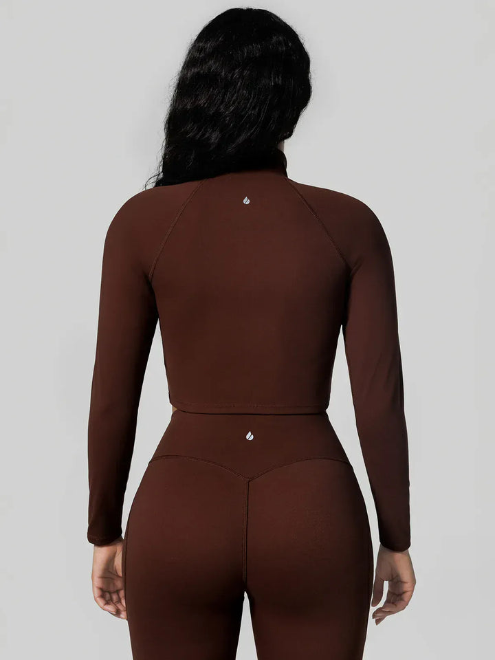 A model wearing a BRXL® Half Front Zipper Activewear Cropped Top in