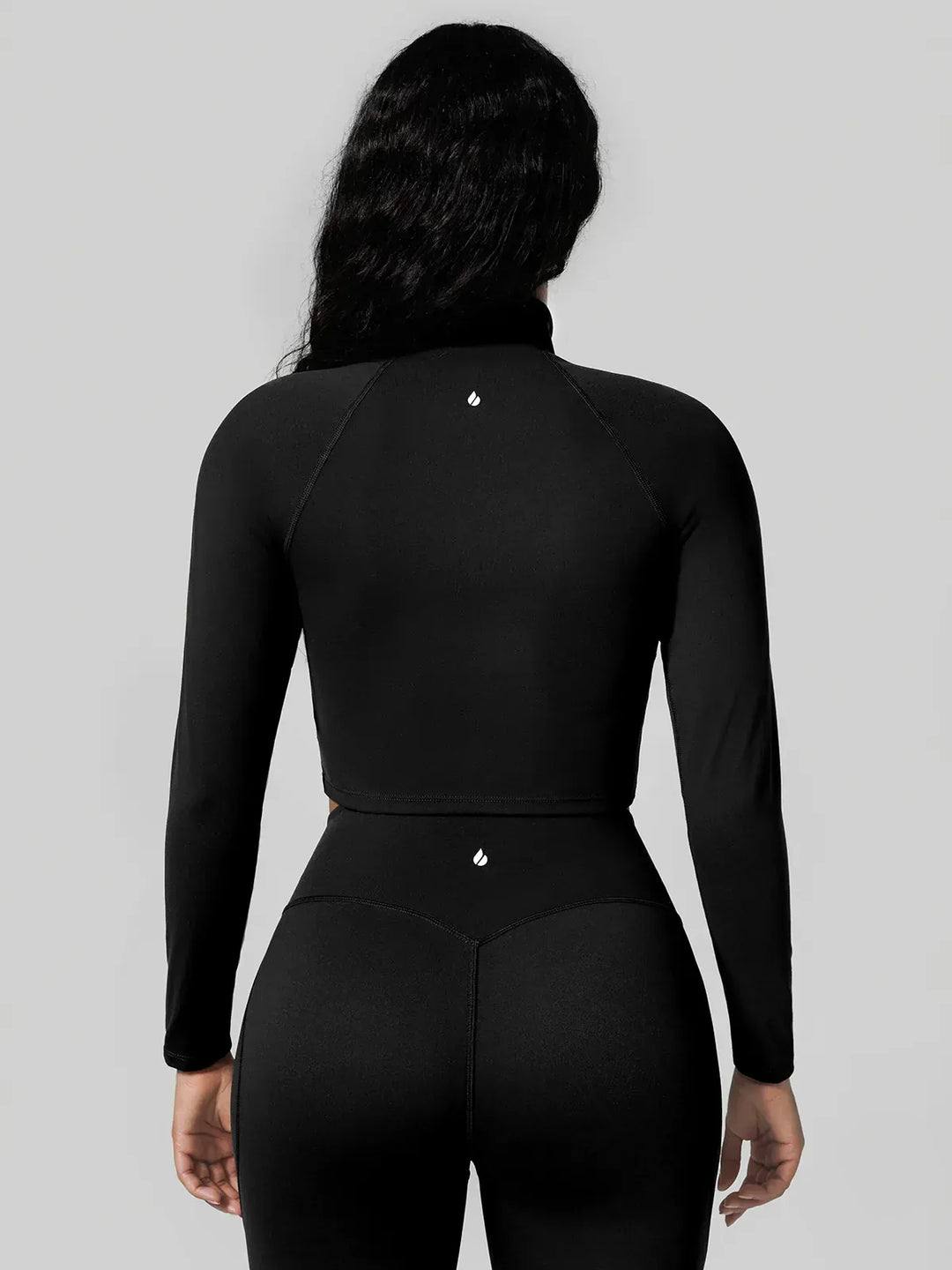 A model wearing a BRXL® Half Front Zipper Activewear Cropped Top in