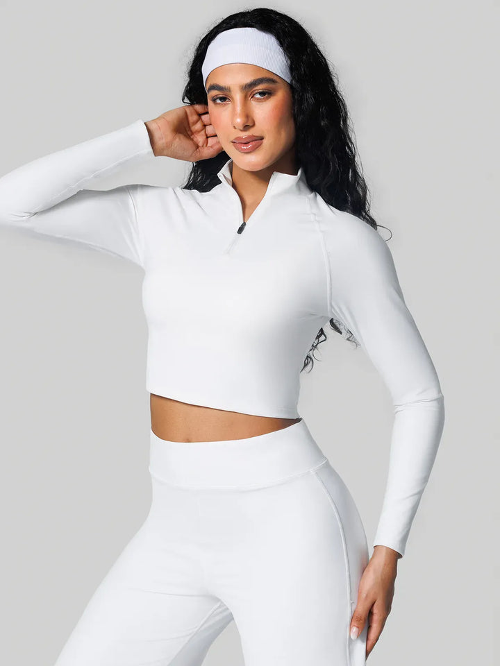 A model wearing a BRXL® Half Front Zipper Activewear Cropped Top in White / XS