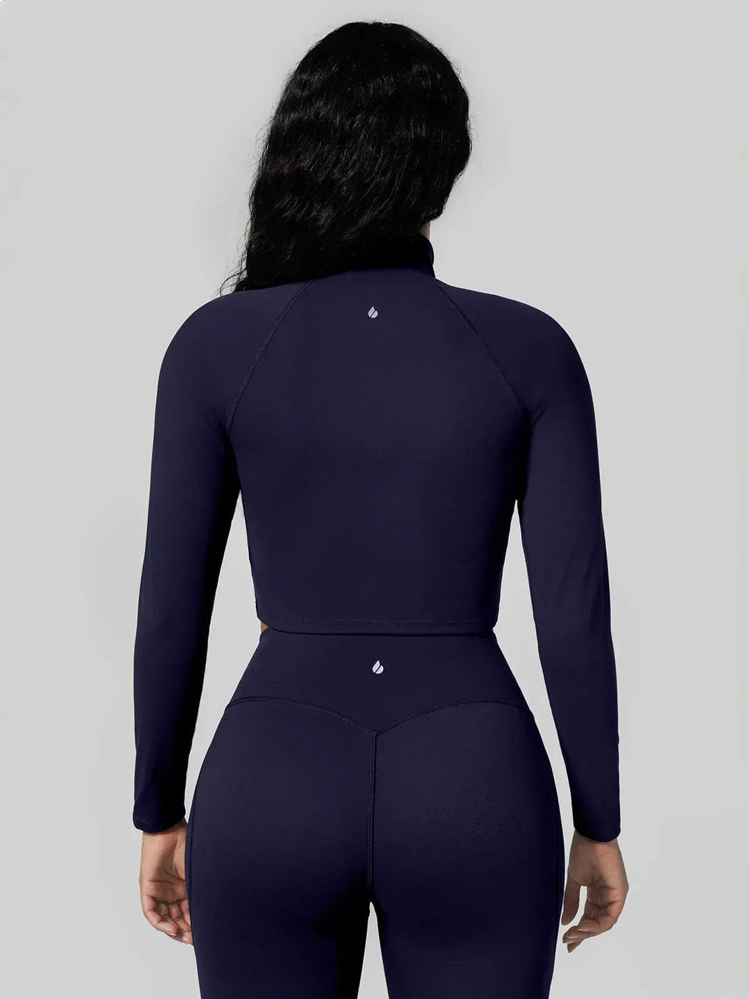 A model wearing a BRXL® Half Front Zipper Cropped Top Seamless Butt-Lifting Leggings Set in