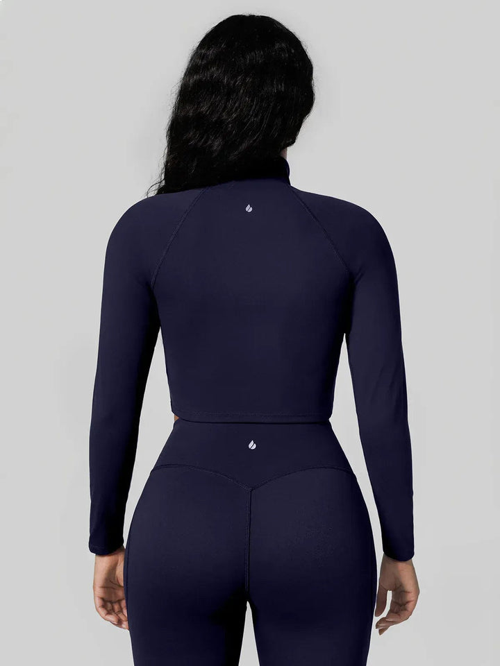 A model wearing a BRXL® Half Front Zipper Cropped Top Seamless Butt-Lifting Leggings Set in