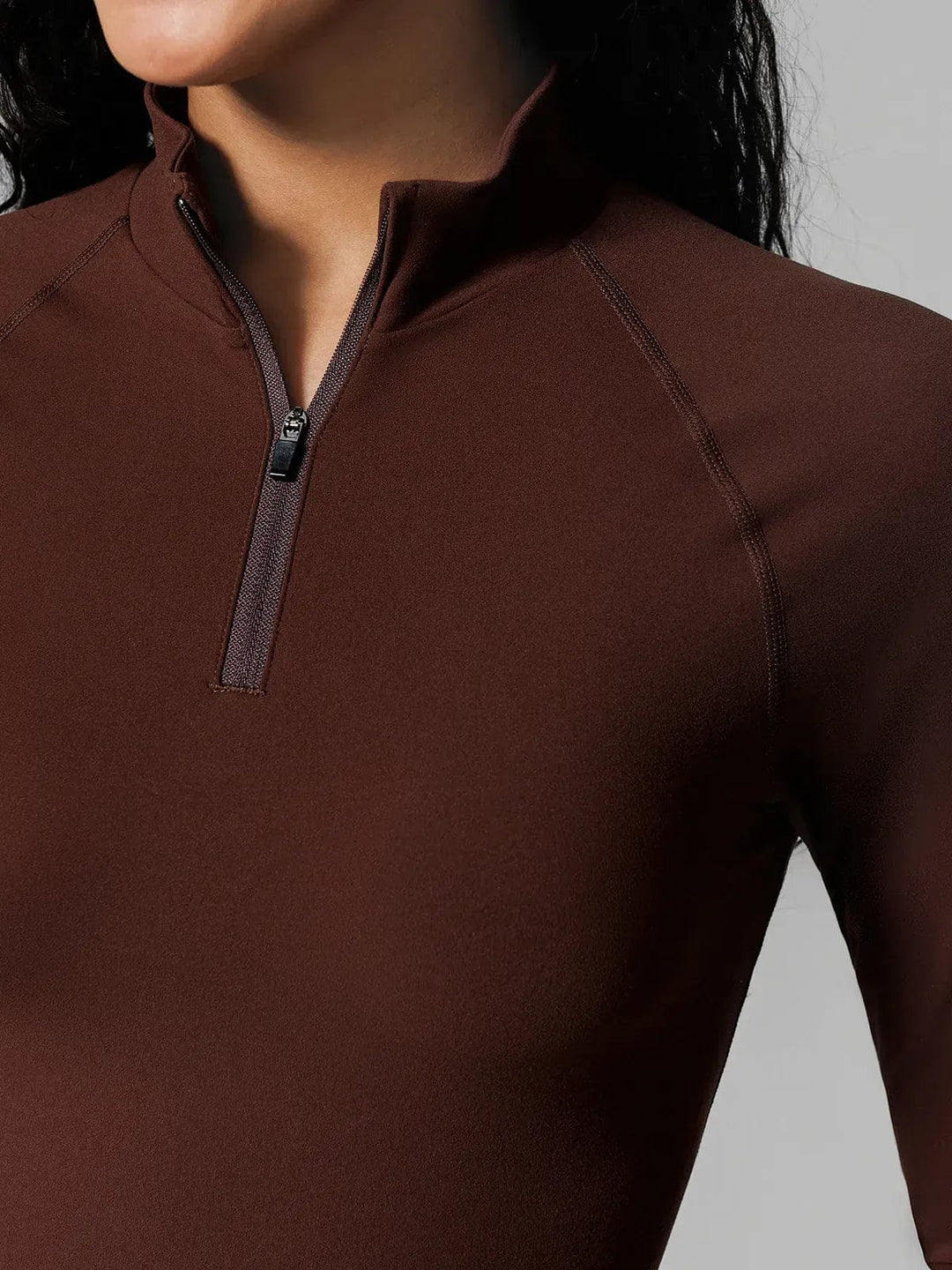 A model wearing a BRXL® Half Front Zipper Cropped Top Seamless Butt-Lifting Leggings Set in