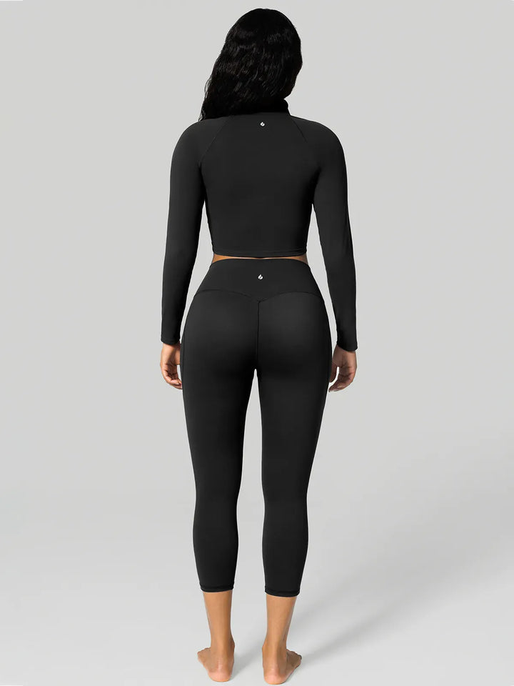A model wearing a BRXL® Half Front Zipper Cropped Top Side Pockets Fleece Lined Leggings Set in