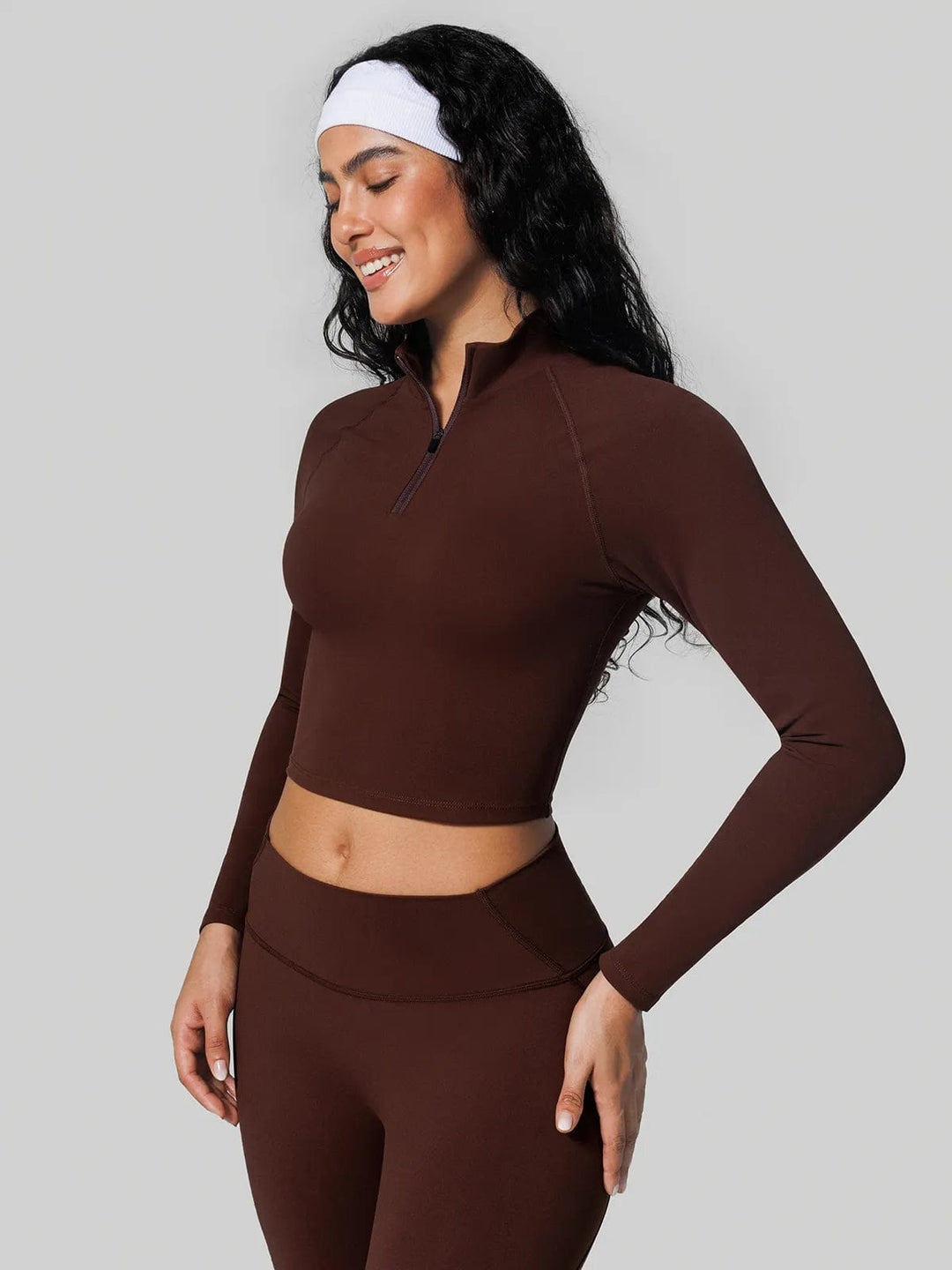A model wearing a BRXL® Half Front Zipper Cropped Top Side Pockets Fleece Lined Leggings Set in