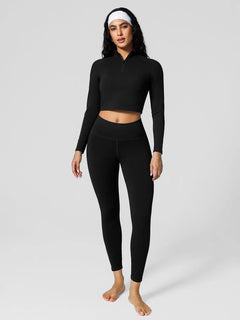 A model wearing a BRXL® Half Front Zipper Cropped Top Side Pockets Fleece Lined Leggings Set in
