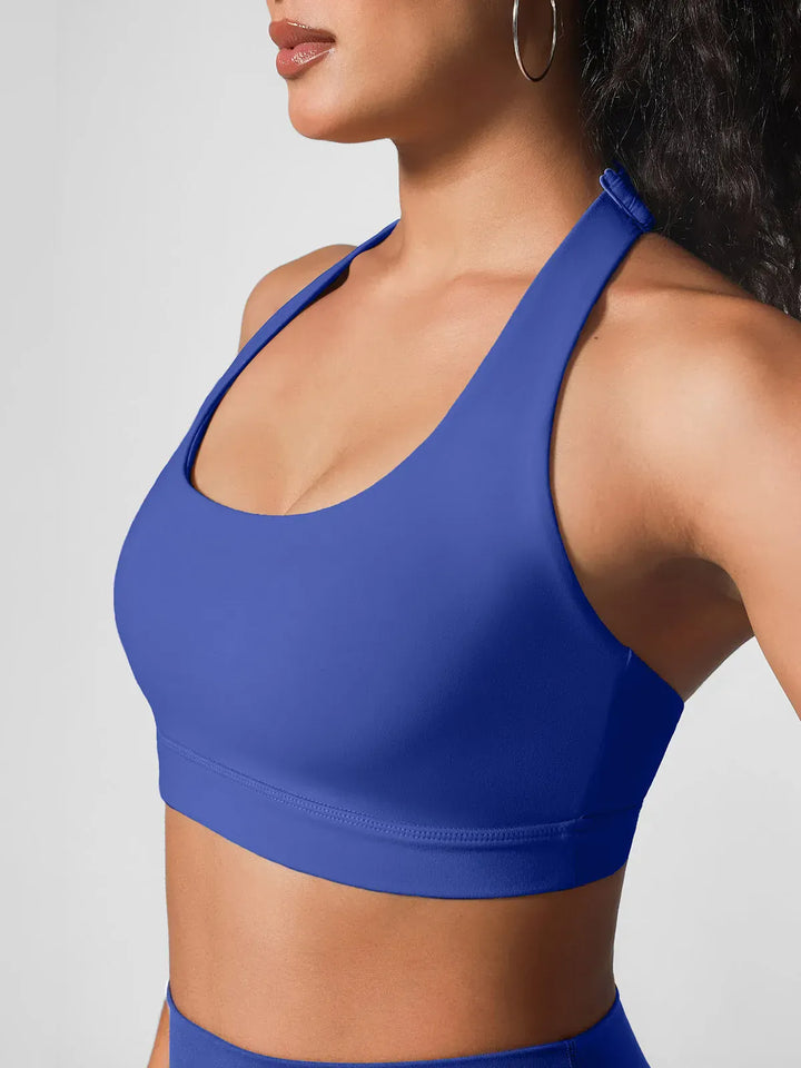 A model wearing a BRXL® Halter-neck Yoga Bra in Blue / XS