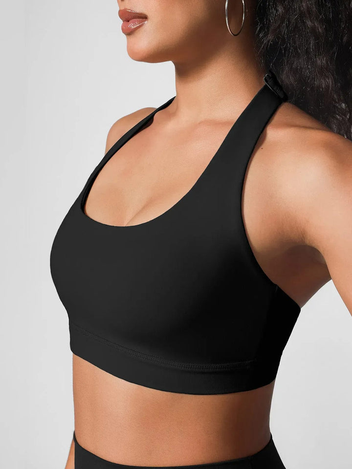 A model wearing a BRXL® Halter-neck Yoga Bra,High Rise Flared Side Pockets Scrunch Leggings in Bra / Black / XS