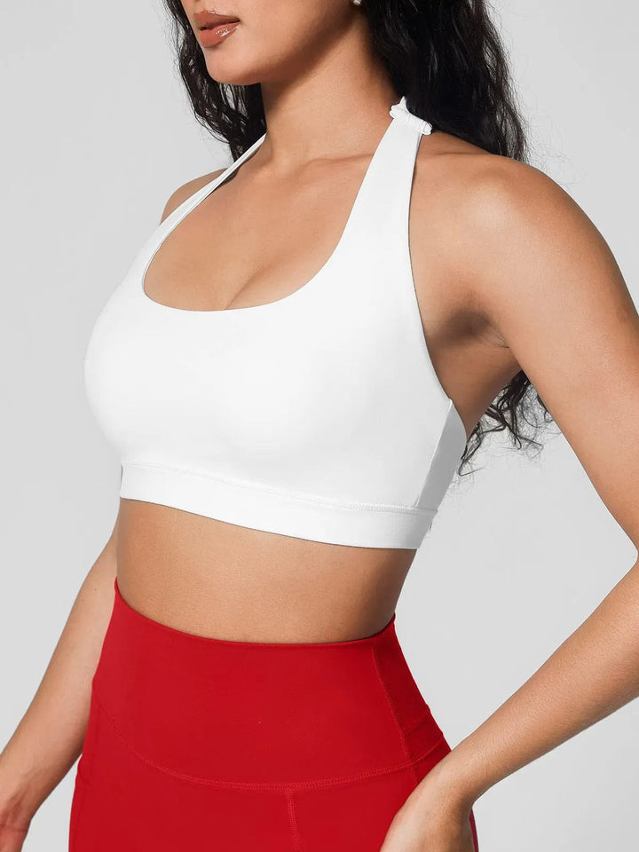 A model wearing a BRXL® Halter-neck Yoga Bra,High Rise Flared Side Pockets Scrunch Leggings in Bra / White / XS