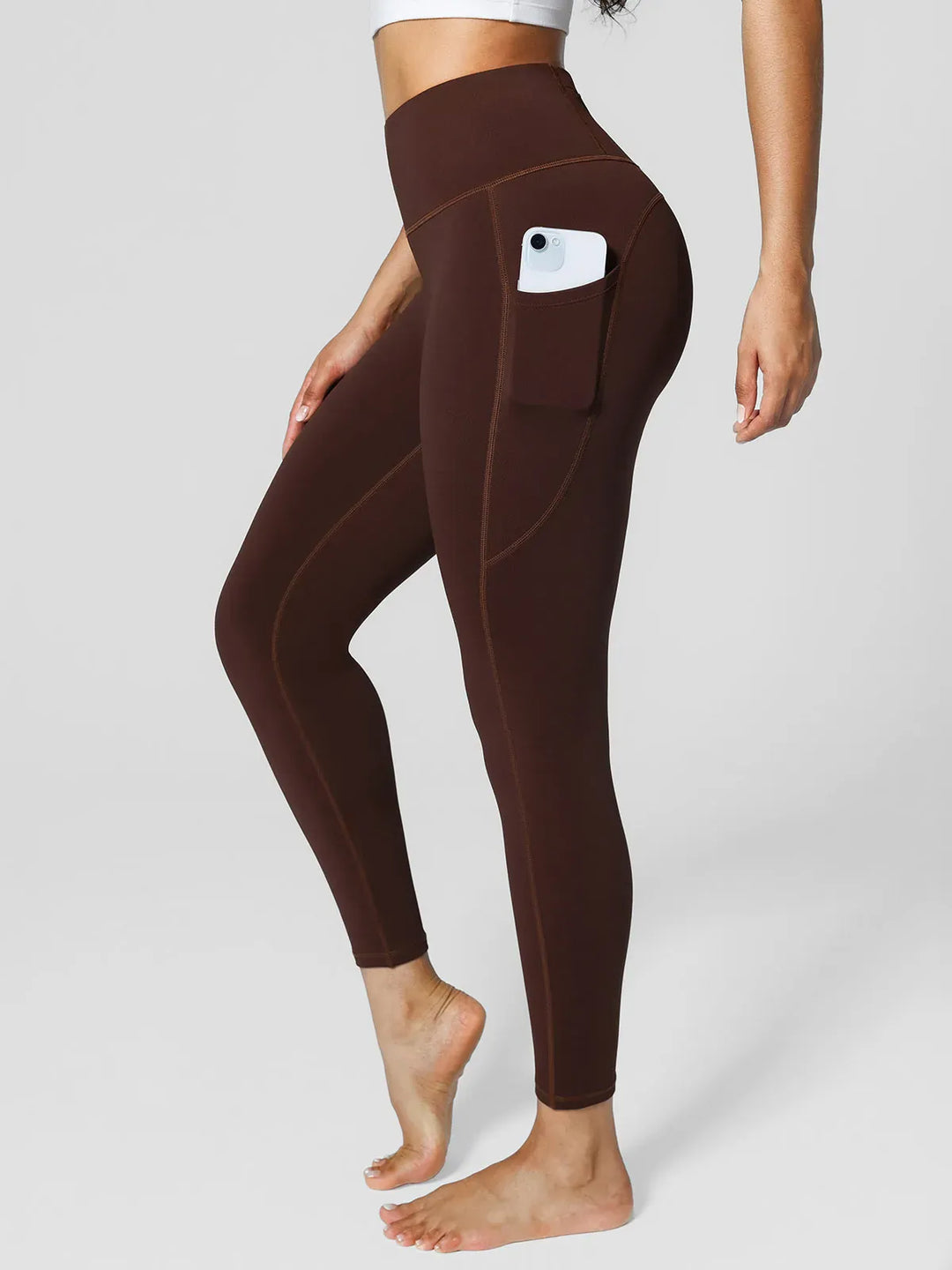 A model wearing a BRXL® High Rise Side Pockets Fleece Lined Leggings in Brown / XS