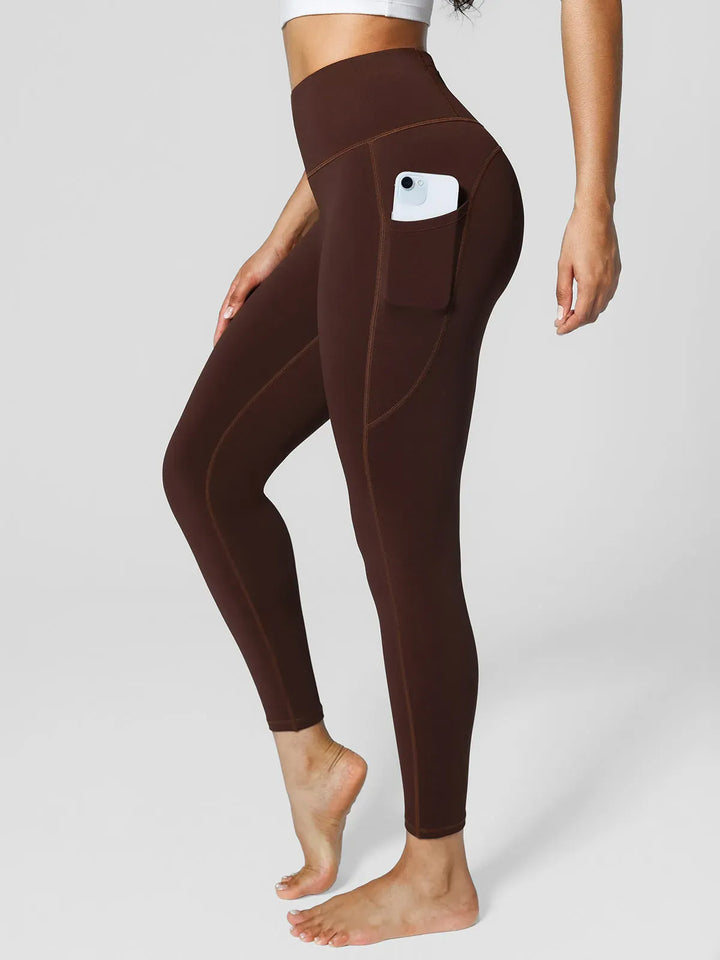 A model wearing a BRXL® High Rise Side Pockets Fleece Lined Leggings in Brown / XS