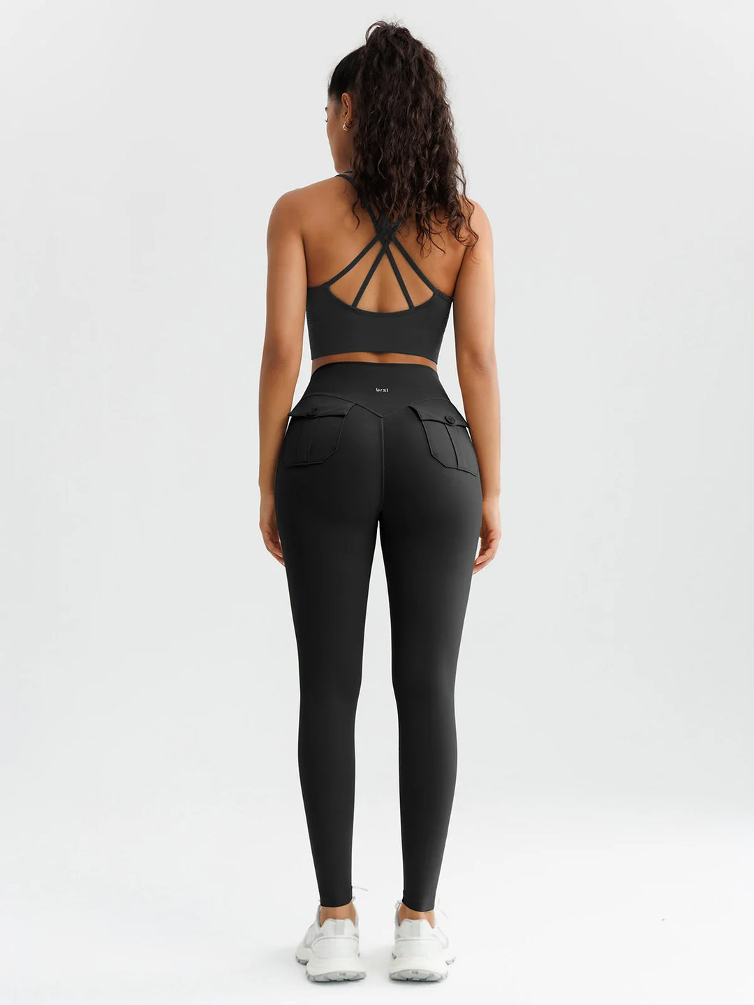 A model wearing a BRXL® High-Waisted Hidden Scrunch Leggings with Cargo Pockets