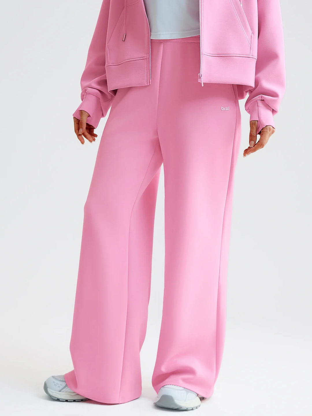 A model wearing a BRXL® Lightweight Mid-Rise Wide Leg Baggy Sweatpants Baby Pink / XS