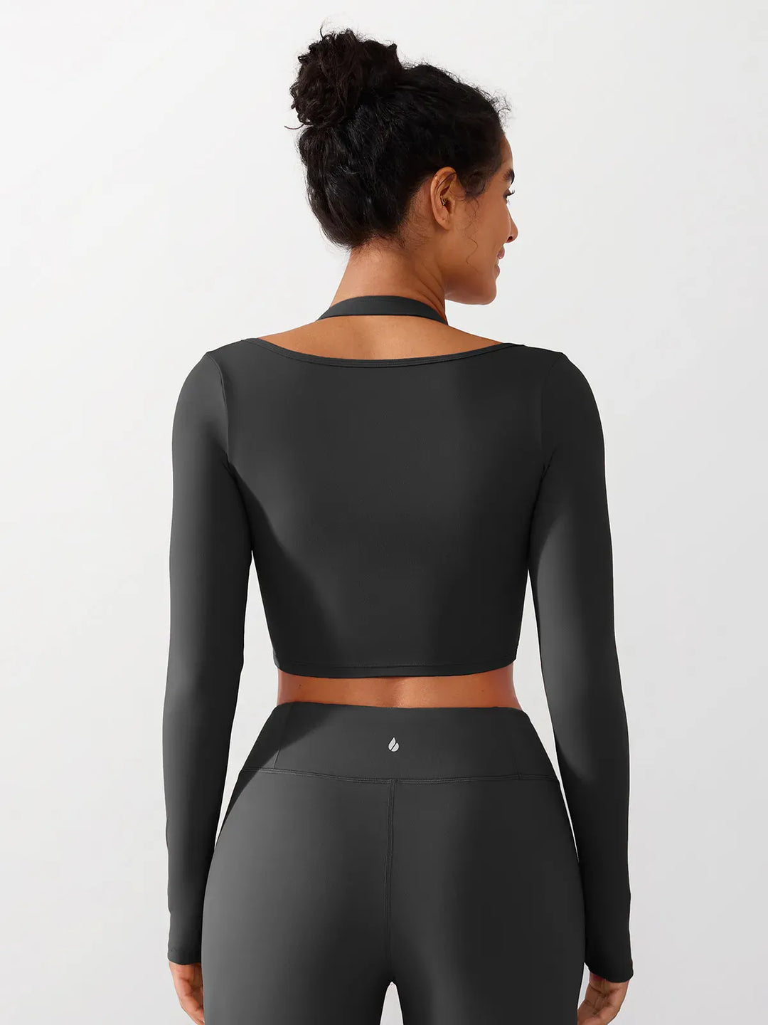 A model wearing a BRXL® Long Sleeve Halter Shrug Top with Buckle and Thumbhole in