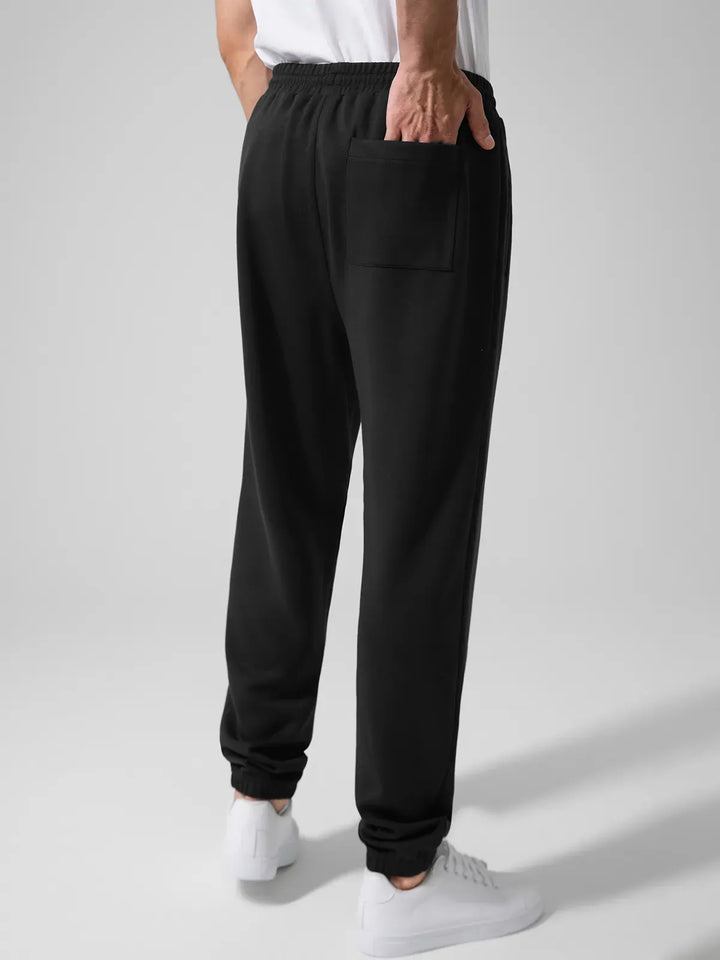 A model wearing a BRXL® Men's Four Pockets Drawstring Waist Activewear Sweatpants in
